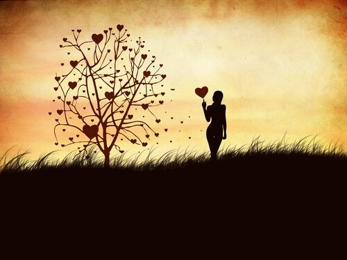 Femme-avec-un-coeur-dans-la-main-devant-l-arbre-des-sentiments