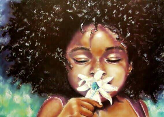 niña-de-color-oliendo-una-flor