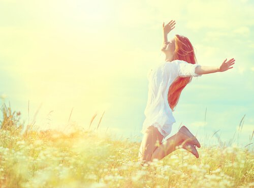 Mujer-feliz-saltando-en-el-campo