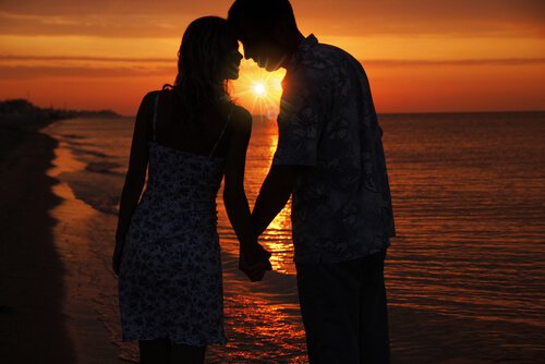 couple face a un coucher de soleil