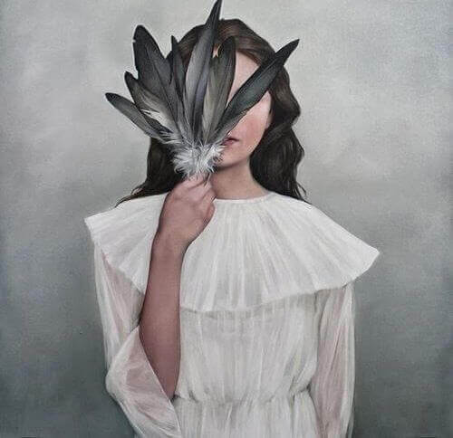 jeune qui se cache le visage avec une plume