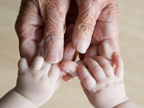 mains d'une personne agee avec celles d'un bebe