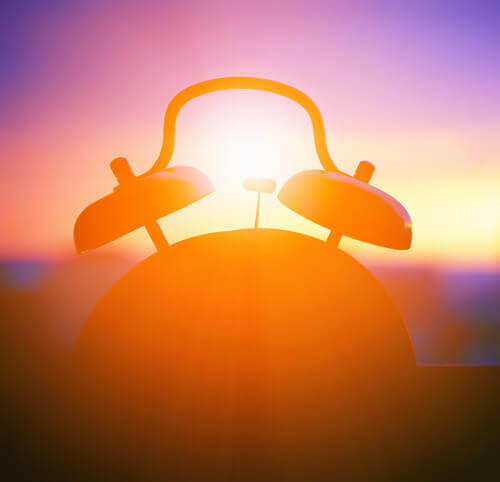 Reloj-en-una-ventana-mientras-amanece