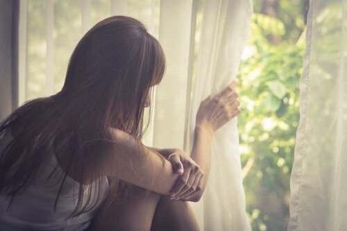 Mujer-triste-pensando-en-su-vida-mirando-por-la-ventana-1