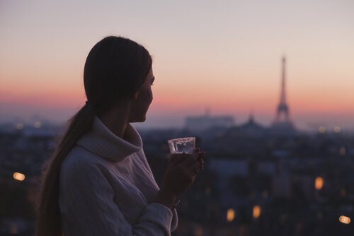 Femme-profitant-de-la-vue-de-paris-avec-un-cafe