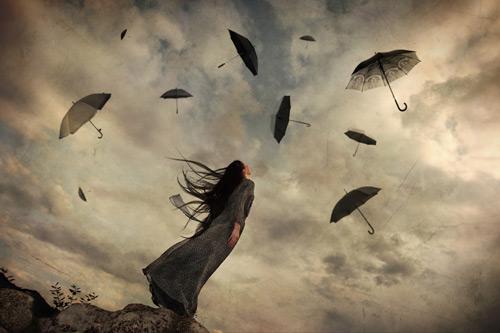 Femme-regardant-des-parapluies-voler-dans-le-ciel