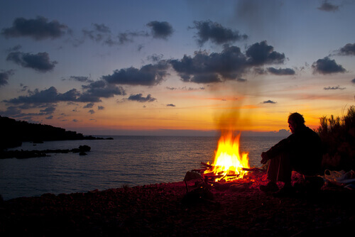 Hombre-al-anochcer-con-fuego-en-la-playa