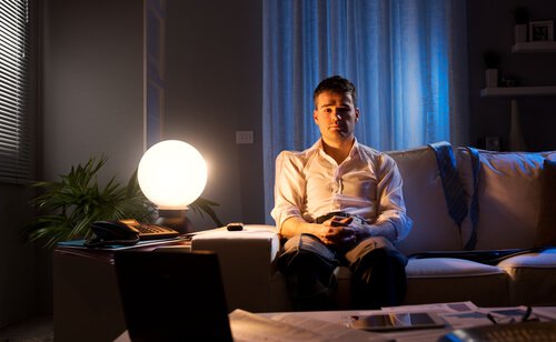 Homme-assis-sur-le-canape-avec-une-lampe