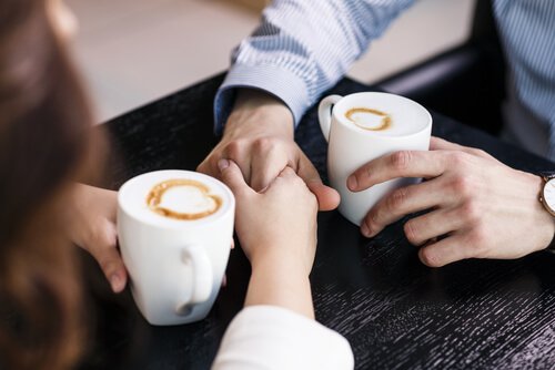 Couple-parlant-se-prenant-les-mains-cafe
