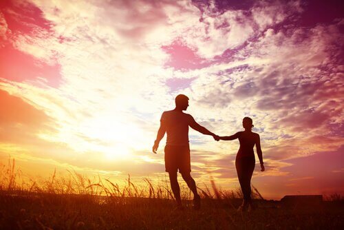 pareja-agarrada-de-la-mano-al-atardecer