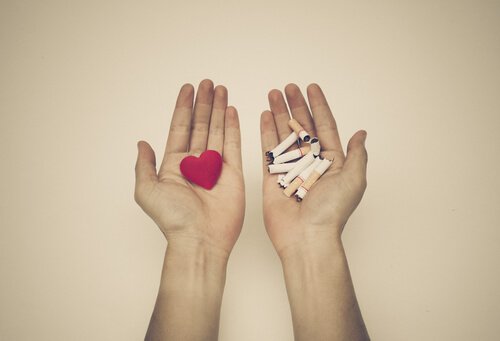 mano-con-un-corazon-rojo-y-mano-con-cigarros