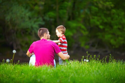 padre-hablando-con-su-hijo-en-el-cesped