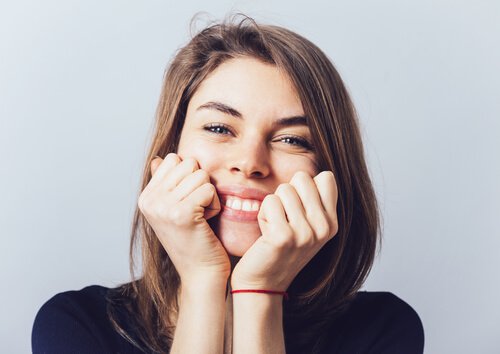 femme-souriant-mains-sur-le-visage