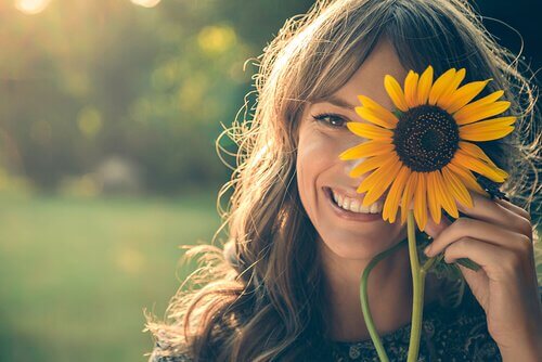 chica-sonriendo-con-un-girasol-en-la-cara