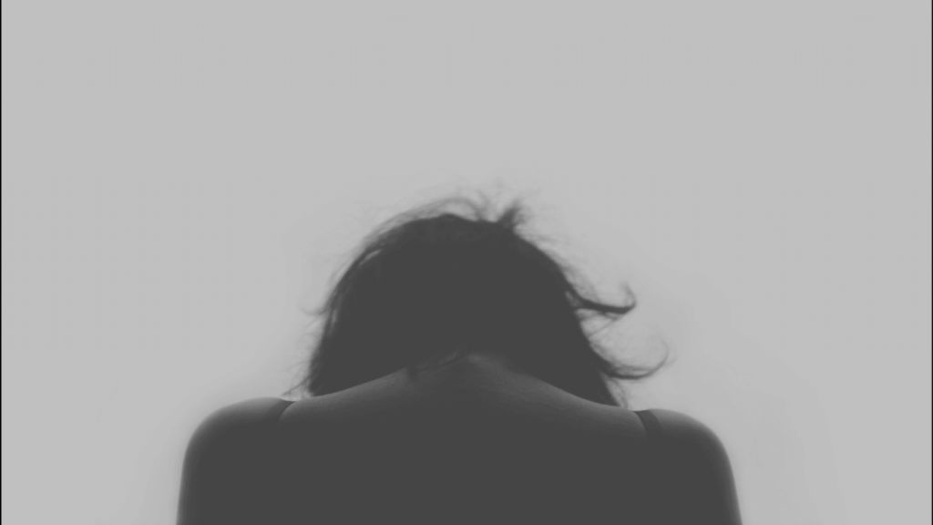 femme de dos avec la tete baissée
