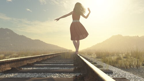 femme heureuse sur une voie ferrée