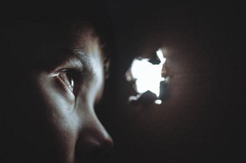 enfant épiant par un trou