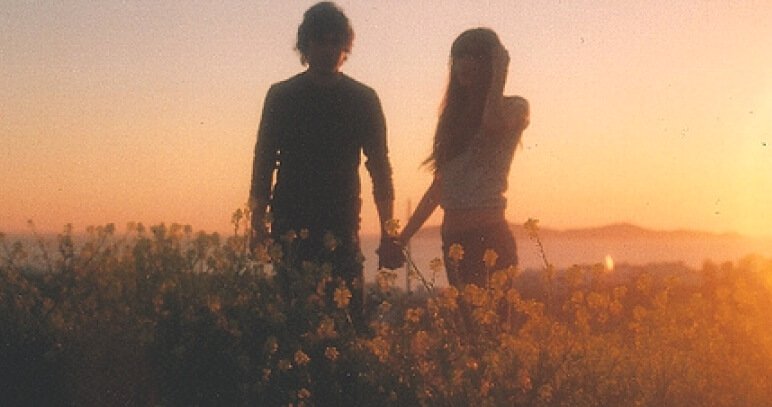jeune couple dans un champ de fleurs