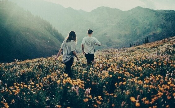 couple promenant dans un champ fleuri