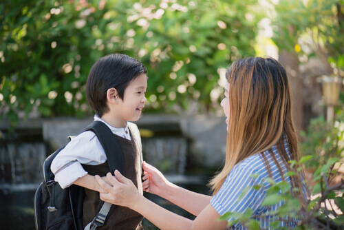 premier jour d'école pour un petit garçon parlant avec sa mère