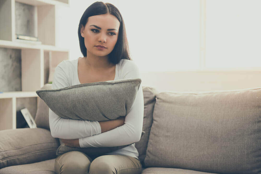 femme triste tenant un coussin