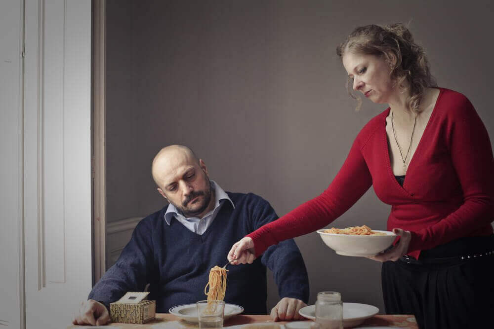 Femme servant de la nourriture à son mari