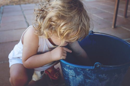 enfant gaucher regardant dans un seau