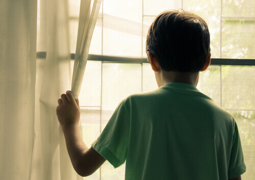 enfant qui regarde par la fenêtre