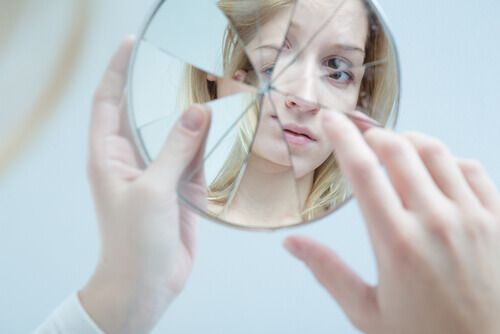 femme qui se regarde dans un miroir brisé