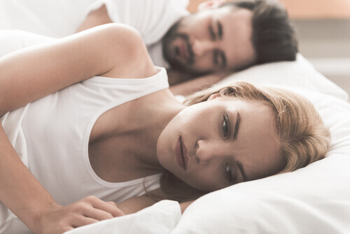 femme réveillée et pertrubée par les problèmes sexuels avec son conjoint