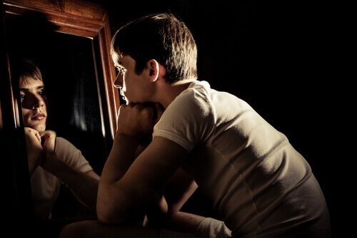 jeune adolescent qui se regarde dans un miroir