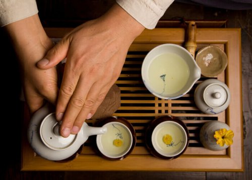 mains qui tiennent une théière