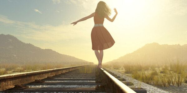 Femme qui marche sur la voie ferrée