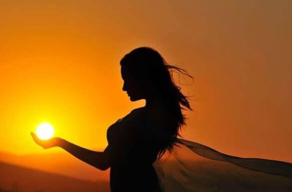 femme tenant le soleil dans ses mains