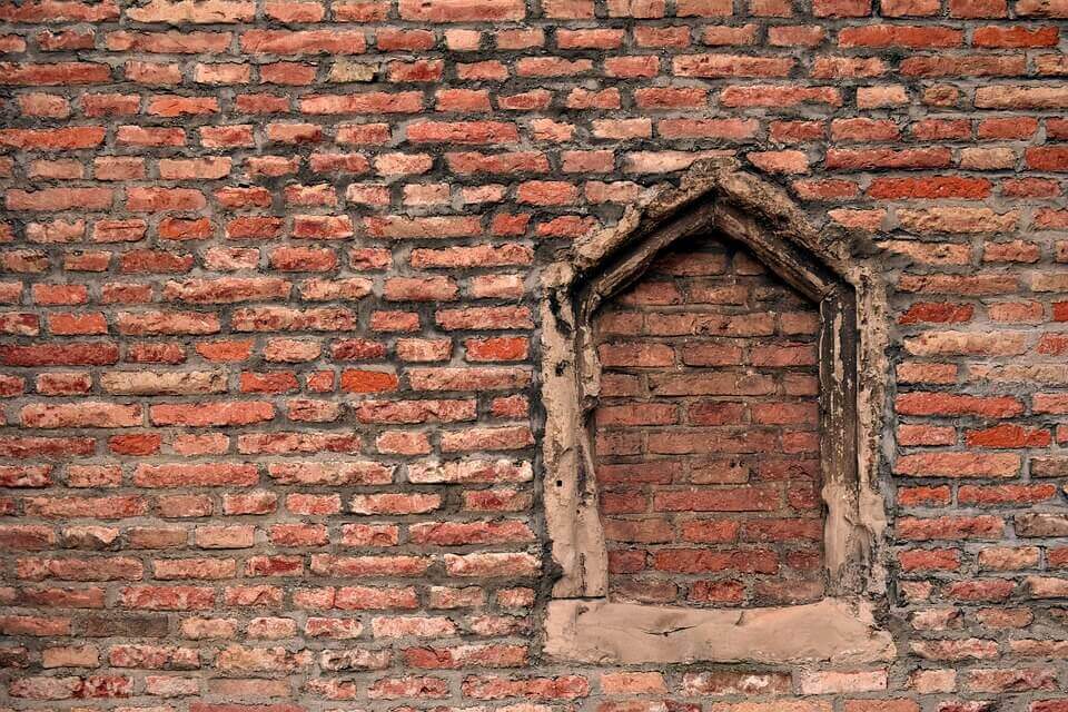 fenêtre cassée bouchee par des briques