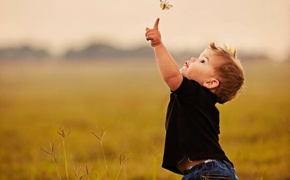 enfant essayant d'attraper un papillon