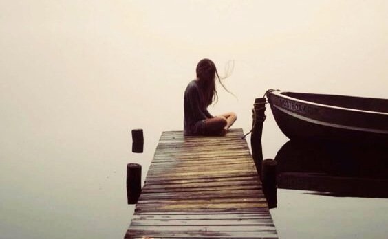 femme assise au bout d'un ponton