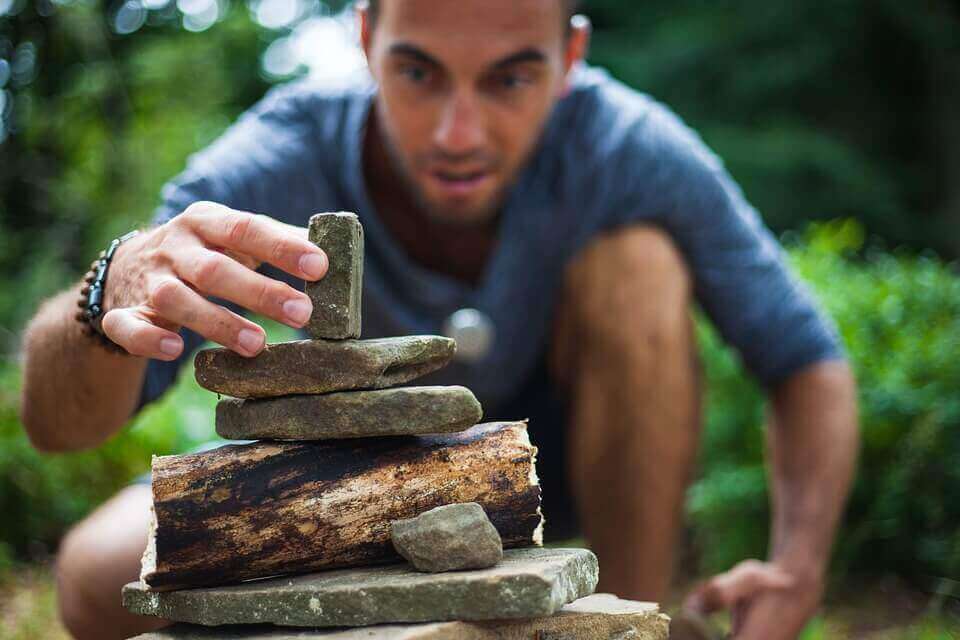 homme superposant des pierres