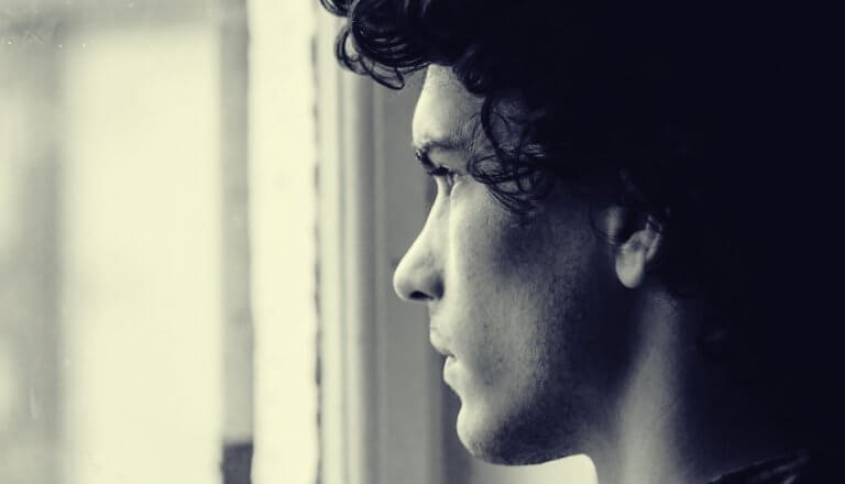 homme regardant par la fenêtre