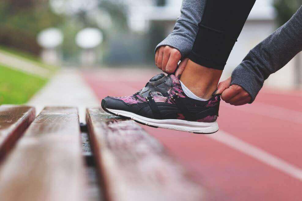 personne qui met des chaussures de sport