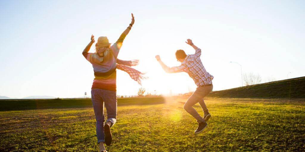 couple sautant dans le champ