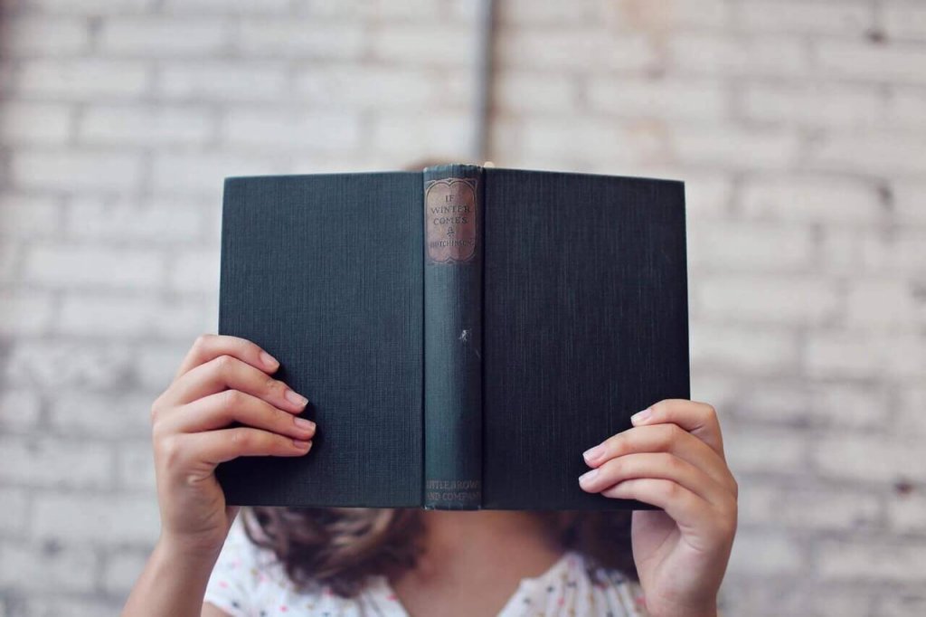 Femme avec un livre devant le visage
