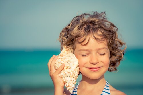 enfant qui écoute dans un coquillage