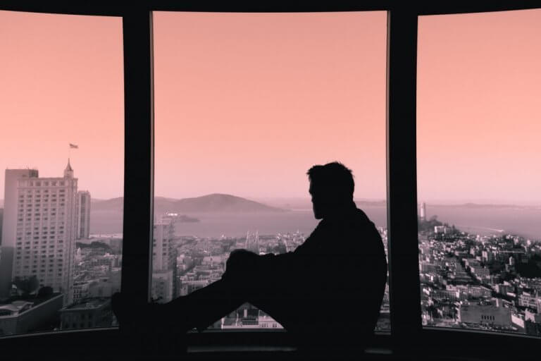 homme regardant par la fenêtre