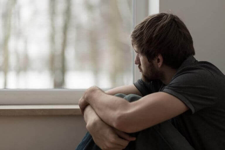 homme pensif regardant par la fenêtre
