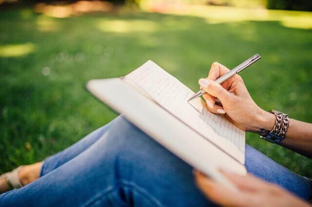 femme qui tient un journal de bord de ses séances de yoga