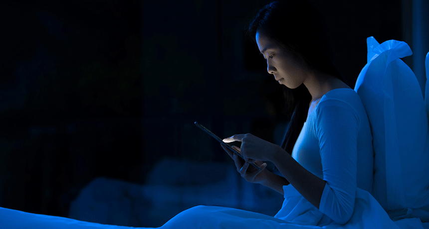 femme regardant le mobile la nuit, touchée par le syndrome des vibrations fantômes