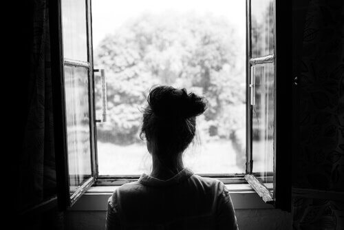 femme pessimiste face à la fenêtre
