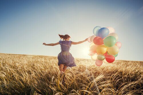 femme courant dans un champ avec des ballons
