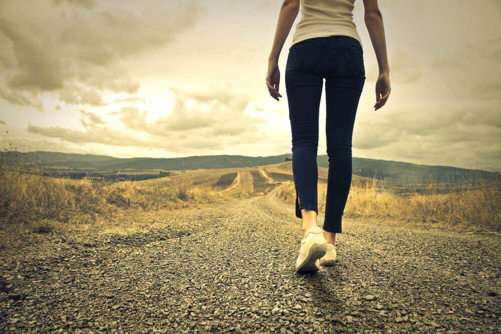 Femme qui marche sur un chemin